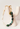 A beaded keychain with white heart-shaped beads, dark green polished beads, light green marbled beads, and gold-toned metal hardware, displayed on a cream ceramic stand.